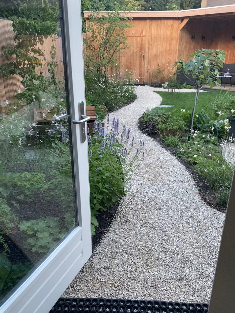 Tuinontwerp met grind pad overkapping en bloemen en planten